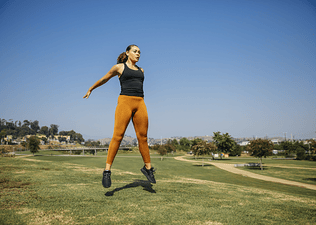 Woman jumping while exercising at outdoor park