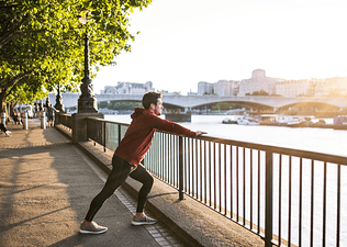 Man does a calf stretch outdoors after a run
