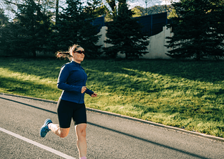 Woman practicing how to stop overstriding while runing outside.