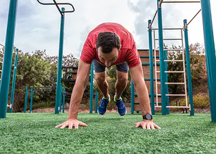 Man does a burpee exercise outdoors