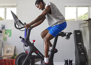 Man rides indoor Peloton Bike at home 