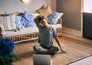 Woman does upper body stretches at home 