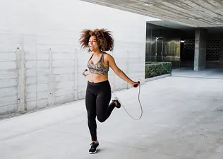 Woman jumping rope outdoors, an example of cardio without running 