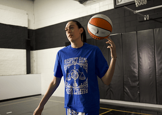 WNBA All-Star Breanna Stewart spinning a basketball on her finger on an indoor basketball court