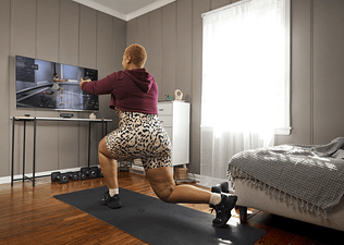 Woman works out at home with Peloton Guide