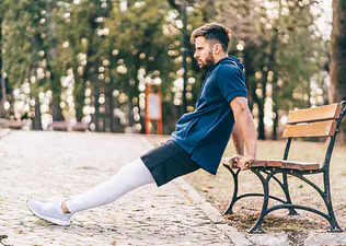 Man doing Tricep Dips in park 