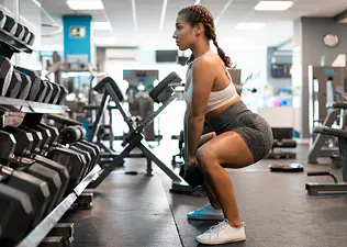 Woman does a squat exercise at the gym