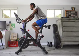 Man riding Peloton on Bike