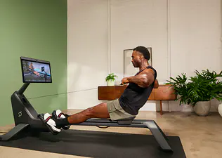 Man exercising on Peloton Row activating all the muscles worked by rowing.
