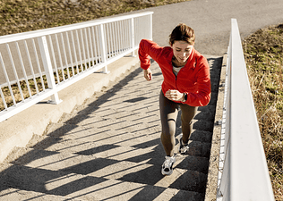 Woman runs on stairs outdoors 