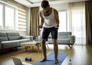 Man working out at home with resistance bands and weights 