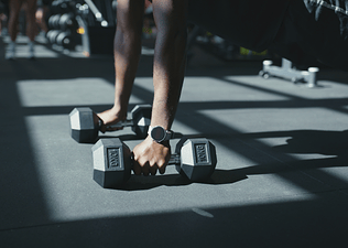 Man doing a renegade row while strength training wondering how much weight he should be lifting.