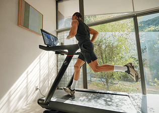 Young man doing treadmill running to build muscle on a Peloton Tread
