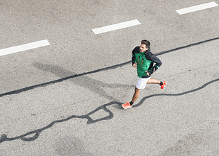 Young man running on a road doing his longest run before a marathon