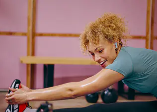 Peloton member doing cooldown exercises and stretching after a workout.