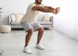 A close-up photo of a man's knees while engaging in a squat.