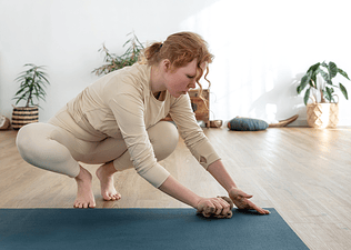 A woman cleaning her yoga mat with a cloth.
