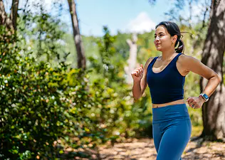 Woman doing interval walking training (aka Japanese walking) outside in a park.
