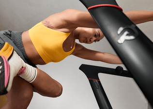 Woman stretching on Peloton treadmill