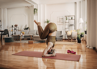 Woman doing a yoga headstand during a home yoga practice
