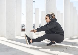 Woman practices a single leg or pistol squat 