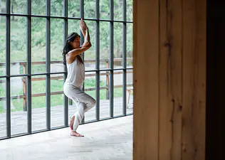 Photograph of woman doing Eagle Pose in yoga clothing