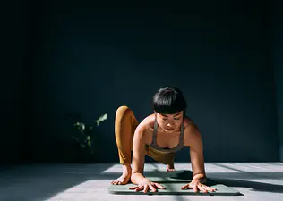 Woman doing Lizard Pose in yoga in a studio space