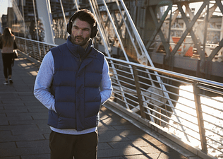 Peloton instructor Jon Hosking walking to commute to work while listening to a meditation on his headphones.