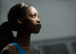 A focused athlete looking up into the light.