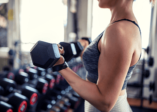 Woman lifting weights at gym 