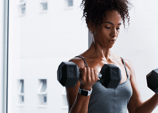 Woman does a beginner dumbbell workout at home