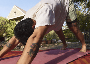 Peloton member doing downward dog, a yoga position