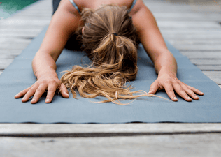 Woman practices Child's Pose (Balasana) in yoga