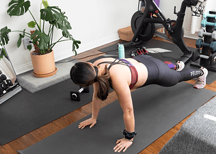 woman in a plank pose on a yoga mat at home