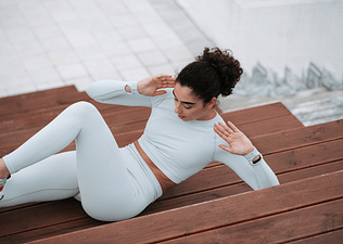 Photo of woman doing bicycle crunches outside