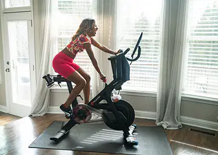 Woman rides Peloton Bike at home