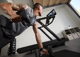 Man doing a Bike Bootcamp workout class at home using a Peloton Tread.