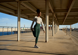Woman doing Quad Stretch outside before going on run