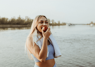 Woman in workout clothes eating an apple