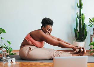 Woman does glute stretches on a yoga mat
