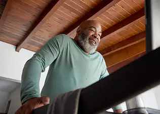 A man happily exercising while walking on the Tread. Learn more about how exercise relieves stress in this article.