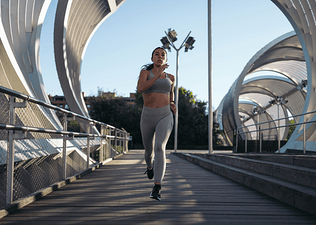 Woman running through city bridge