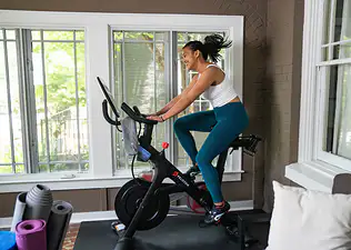 Woman riding on a Peloton Bike