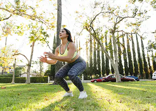 Woman does a jump squat outdoors 