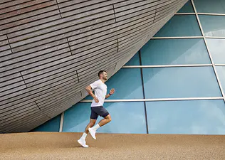 Man uses a half marathon training plan with Peloton while running outside