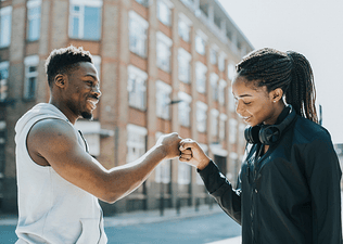 Man and woman fistbumping outside