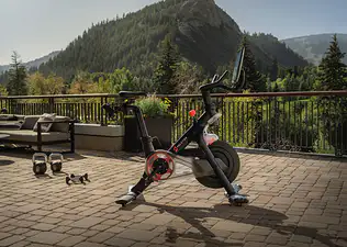 A Peloton Bike on a hotel patio with a mountain in the background