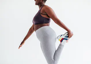 A young woman stretching her leg. Stretching is a key part of injury prevention.