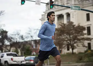 A man practicing discipline by going on a jog through the city.
