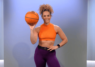 Peloton instructor Jess Sims poses with a basketball for her strength for basketball program on the Peloton App